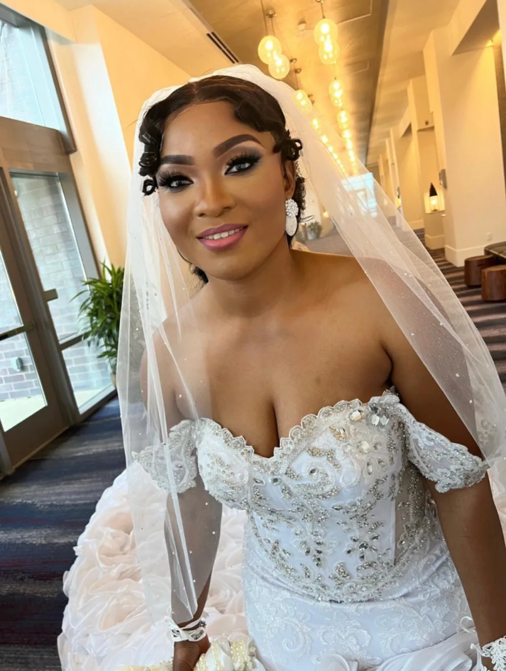 Bride in beaded gown and veil with soft glam bridal makeup